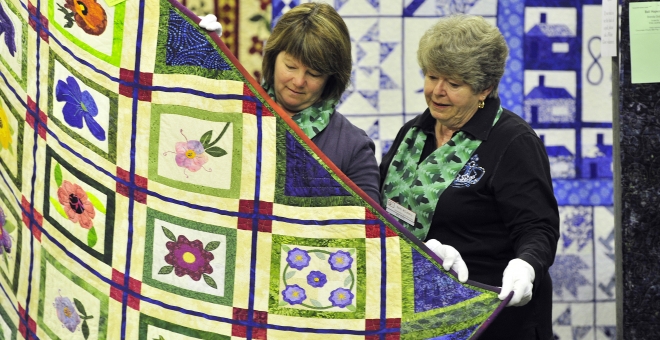Volunteers admiring a quilt from the fair