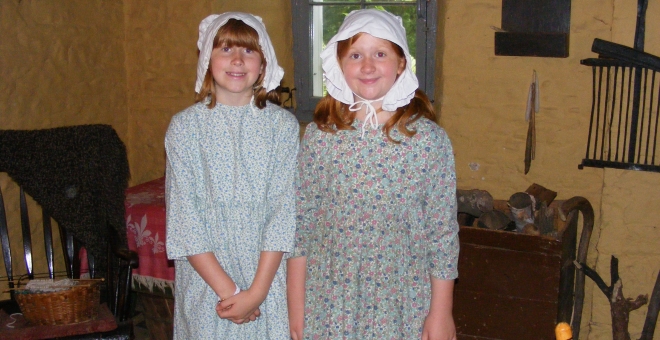 two children dressed as pioneer children