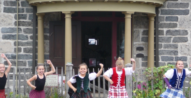 dancers in front of cottage