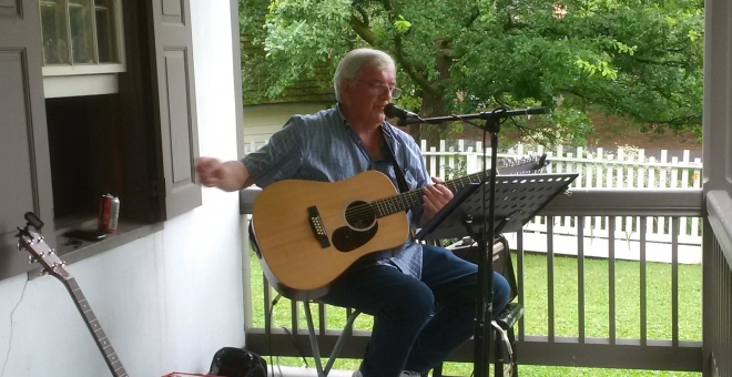 man playing guitar on porch
